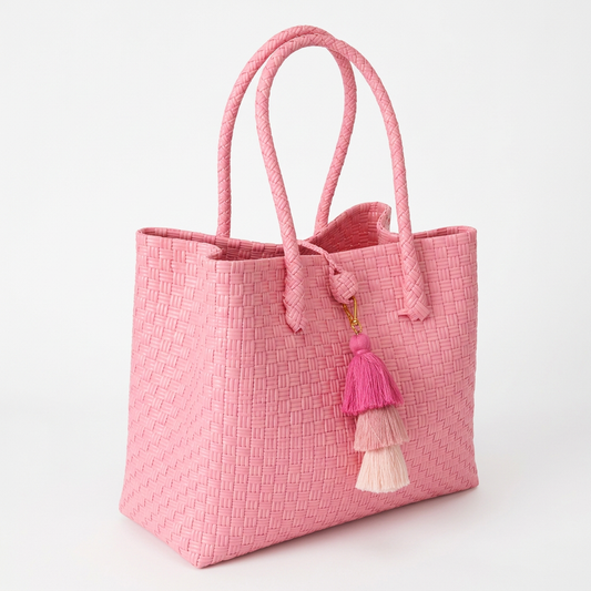 Habi Ganda pink handwoven tote bag with tiered tassel charm, 30-degree angle view