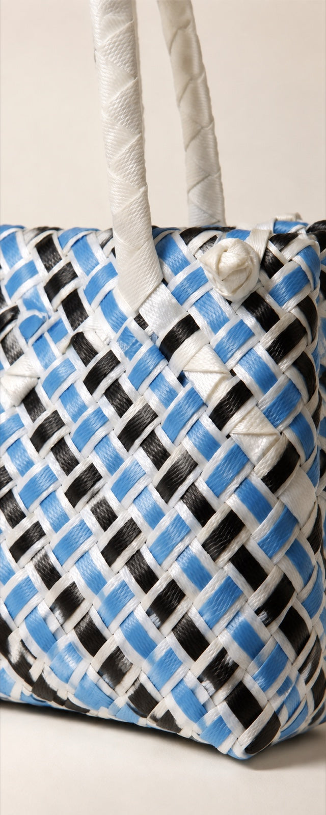 A black and white ISA BAYONG bag taking shape from woven plastic bands